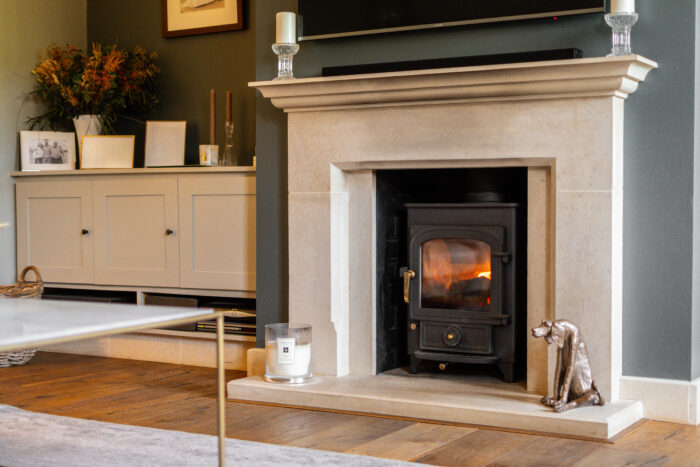 Natural stone fireplace with log burner in a country home living room.