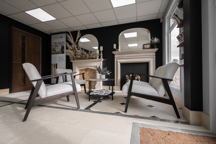 Two chairs in front of fireplaces inside a monochrome living space